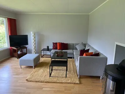 a living room with a couch and a tv at Tunold Gård - Olahuset in Oppstryn