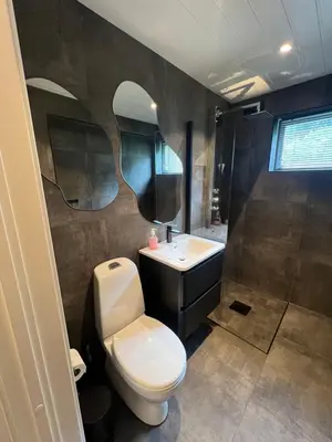 a bathroom with a toilet and a sink at Tunold Gård - Olahuset in Oppstryn