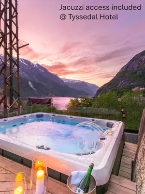 a hot tub with a view of the mountains at Trolltunga Hostel in Tysso