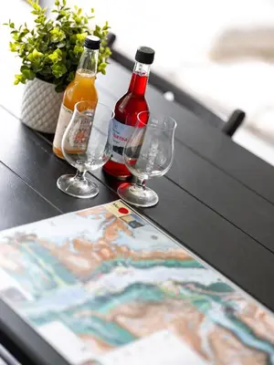 two bottles and glasses on a table with a magazine at Trolltunga Hostel in Tysso