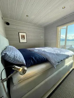 a bedroom with a bed in a room with a window at Villa Blue Dream in Kristiansund