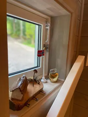 a window in a tiny house with a table and a flag at Villa Blue Dream in Kristiansund