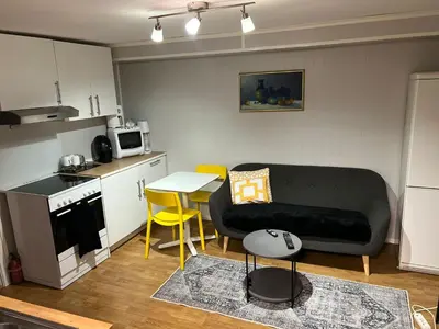 a living room with a couch and a table and a kitchen at Trondheim, Kroppanmarka Tiller in Trondheim