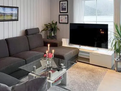 a living room with a couch and a flat screen tv at 6 person holiday home in Gursken-By Traum in Larsnes