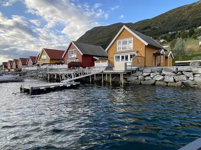 a row of houses on a dock next to the water at 6 person holiday home in Gursken-By Traum in Larsnes