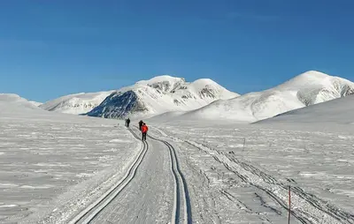 two people walking on a snow covered field with a mountain at Stunning Home In Kvam With Wifi in Kvam