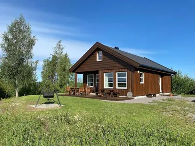 a small wooden house with a swing in the yard at Hytte i landlige omgivelser på Hadeland in Gran