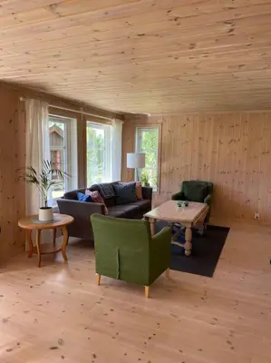 a living room with a couch and a table at Hytte i landlige omgivelser på Hadeland in Gran