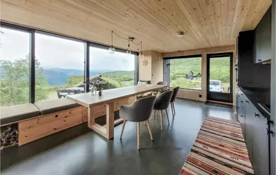 a dining room with a table and chairs and windows at Beautiful Home In Jøsenfjorden in Gullingen