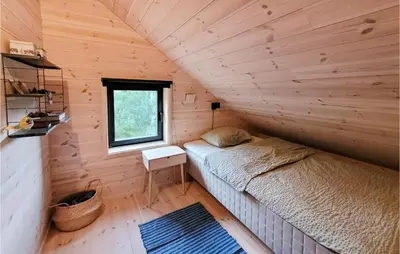 a small bedroom with a bed in a wooden cabin at Beautiful Home In Jøsenfjorden in Gullingen