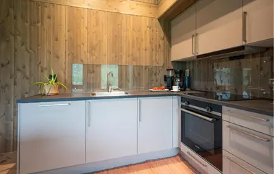 a kitchen with white cabinets and a sink at 3 Bedroom Nice Home In Vøringsfoss in Maurset