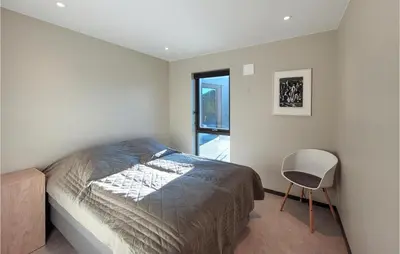 a bedroom with a bed and a chair in it at 5 Bedroom Lovely Home In Urangsvåg in Ervik