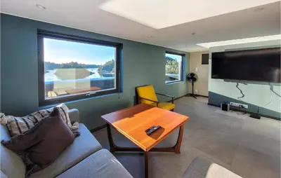 a living room with a couch and a table and a large tv at 5 Bedroom Lovely Home In Urangsvåg in Ervik