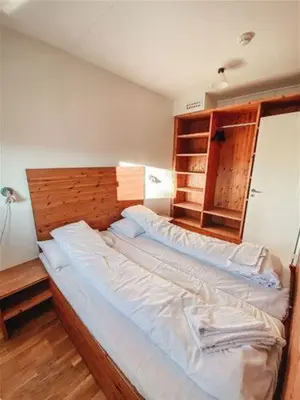 a bedroom with a large bed with a wooden headboard at Hovdestøylen Apartments in Hovden