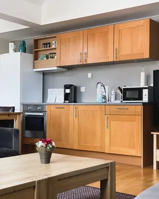 a kitchen with wooden cabinets and a wooden table at Hovdestøylen Apartments in Hovden