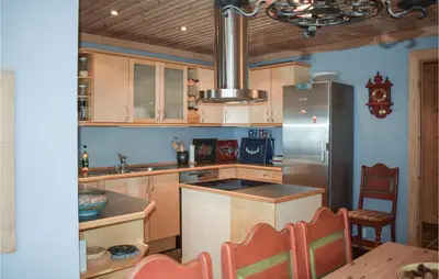 a kitchen with wooden cabinets and a stainless steel refrigerator at Stunning Home In Rjukan With Wifi in Rjukan