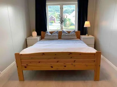 a bedroom with a large wooden bed with a window at Private house in Orkanger, 35 minutes from Trondheim in Orkanger
