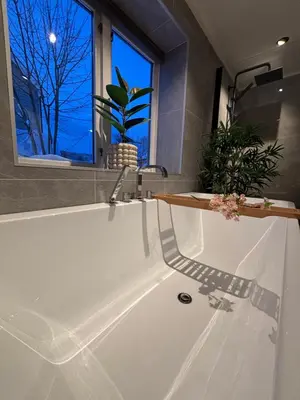 a bathroom with a white tub with a window at Private house in Orkanger, 35 minutes from Trondheim in Orkanger
