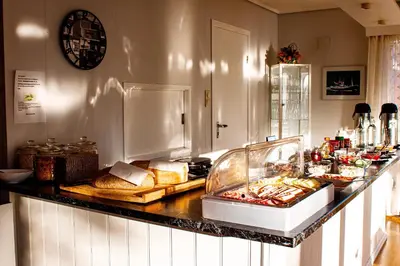 a buffet with bread and other food on a counter at Førde Pensjonat in Førde