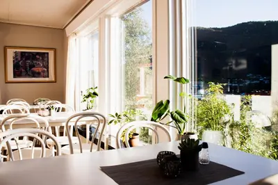 a dining room with tables and chairs and a window at Førde Pensjonat in Førde