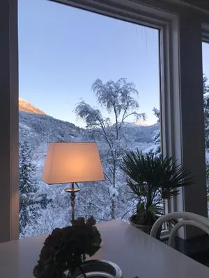 a lamp sitting on a table in front of a window at Førde Pensjonat in Førde