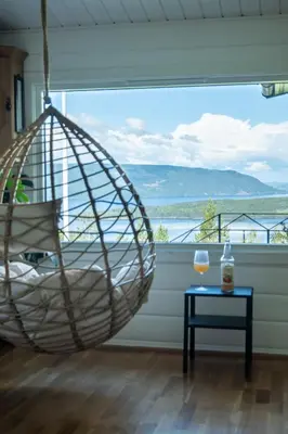 a hanging hammock in a room with a window at Mountain & Lake Haven & Close to Oslo in Stange