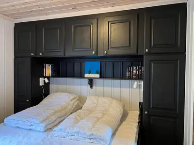 a bed in a room with black cabinets at Bjødnabakkvegen 22C in Beitostøl