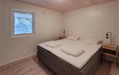 a bedroom with a large bed with a window at 4 Bedroom Amazing Home In Skånevik in Skånevik