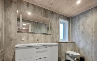 a bathroom with a white sink and a toilet at 4 Bedroom Amazing Home In Skånevik in Skånevik