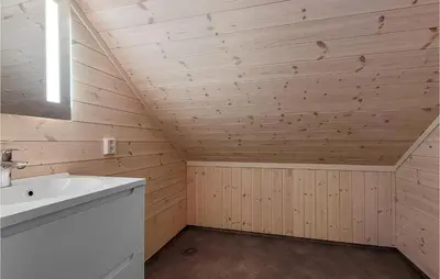 a bathroom with wooden walls and a white sink at 4 Bedroom Amazing Home In Skånevik in Skånevik