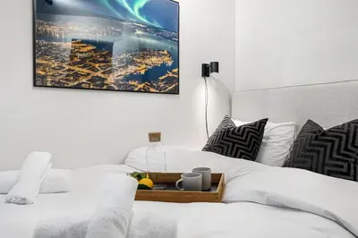 a white bedroom with a bed with a wooden tray on it at King bed - Behind Bryggen - Renovated des 23 in Bergen