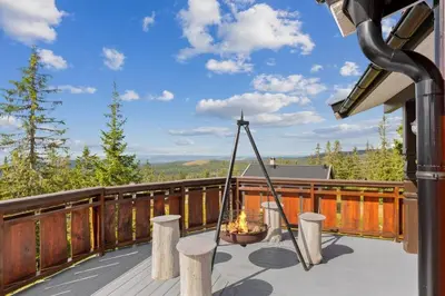 a deck with a hammock on top of a house at Cozy and comfortable cabin in the center of Sjusjøen with a large terrace in Ringsaker
