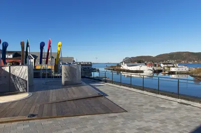 a dock with a marina with boats in the water at Thon Hotel Fosnavåg in Fosnavåg