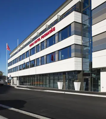 a building with a red sign on the side of it at Thon Hotel Fosnavåg in Fosnavåg