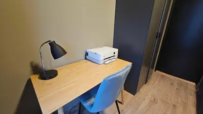 a desk with a printer and a lamp on it at West Coast Apartments Aalesund in Ålesund