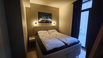 a small bedroom with a bed and a window at West Coast Apartments Aalesund in Ålesund