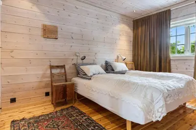 a bedroom with a bed in a wooden wall at Koslig hytte ved Grimsdalen in Dovre