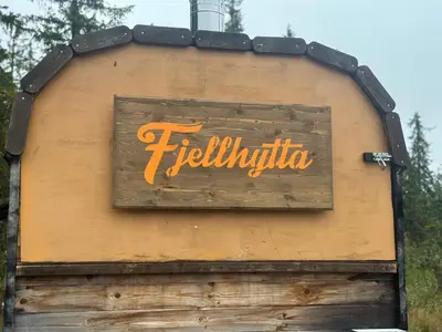 a sign on the side of a building at Høstkos og ro på Budor, 4 roms hytte med peis og wifi in Nordset