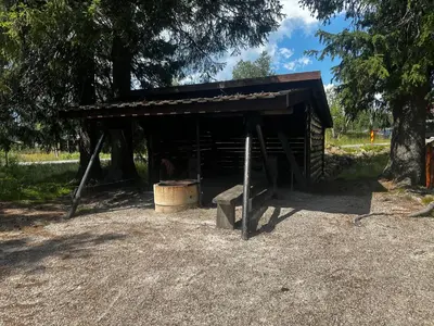 a wooden shed with a barrel and a stove at Høstkos og ro på Budor, 4 roms hytte med peis og wifi in Nordset