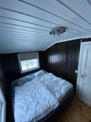a bedroom with a bed in a small room at Høstkos og ro på Budor, 4 roms hytte med peis og wifi in Nordset