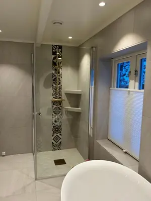 a bathroom with a shower with a glass door at Handelsmannens hus ved Otnesbrygga, Valsøyfjord in Otnes