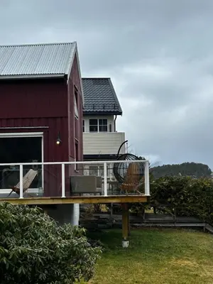 a red house with a deck and a house at Hus ved Valsøyfjorden in Otnes