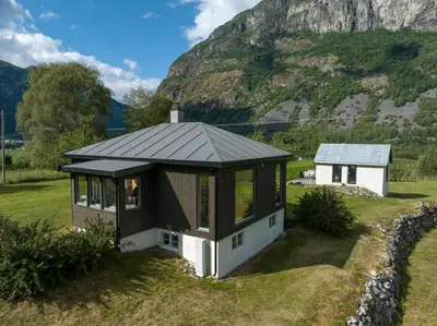 a small house with a grey roof on a field at Jordeplegarden holiday home - Part of a farm - Two buildings - Close to Flåm in Lærdalsøyri