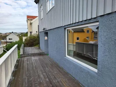a building with a wooden walkway next to a window at Ksu Nordlandet leiligheten in Kristiansund