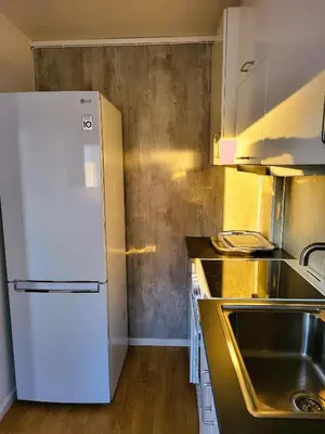 a kitchen with a white refrigerator and a sink at Ksu Nordlandet leiligheten in Kristiansund