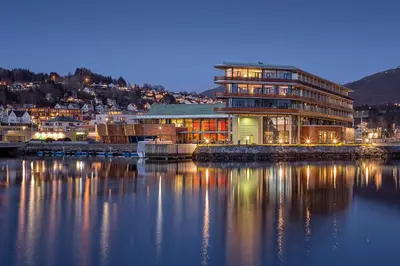 a building next to a body of water at night at Quality Hotel Ulstein in Ulsteinvik