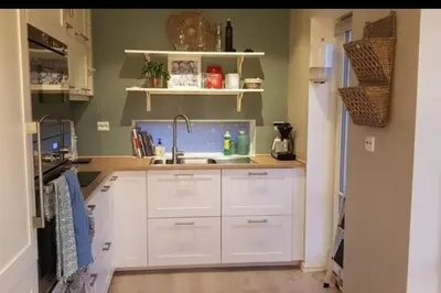 a kitchen with white cabinets and a sink at Fjordcabin Panoramic view Near Bergen 3 sleepingroom in Forland