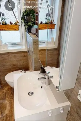 a bathroom with a white sink and a mirror at Fjordcabin Panoramic view Near Bergen 3 sleepingroom in Forland