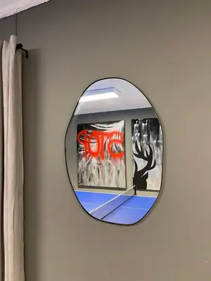 a round mirror on a wall with a painting at Spacious house in Trysil in Trysil