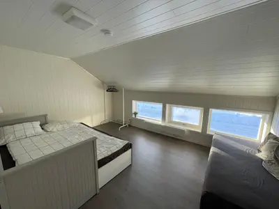 a bedroom with a large bed and two windows at Spacious house in Trysil in Trysil